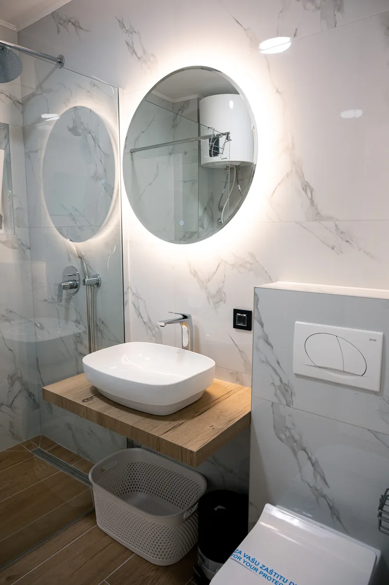 Marble ensuite bathroom with backlit mirror
