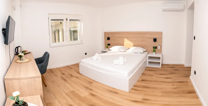 Ensuite apartment I — bedroom with oak headboard and desk