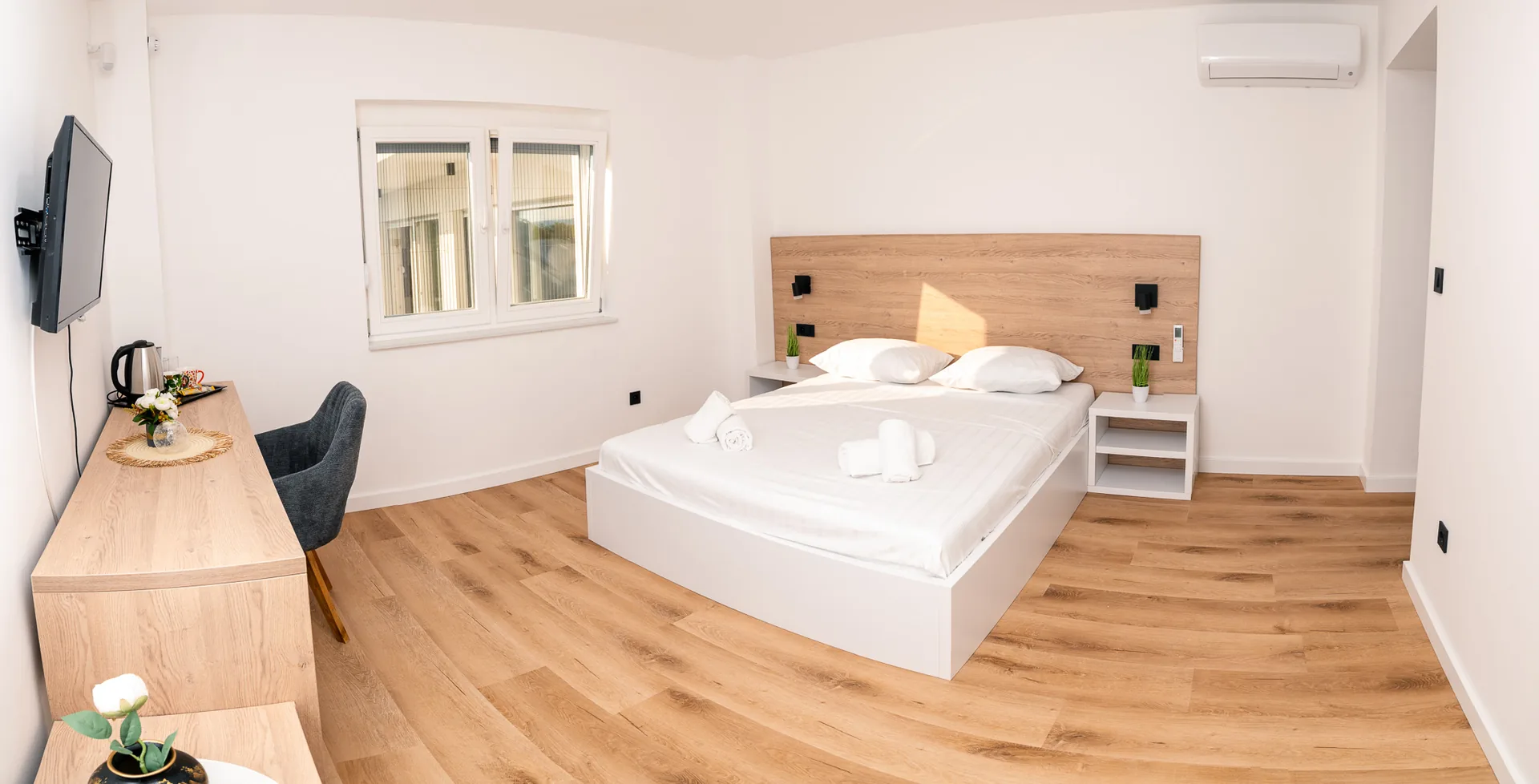 Ensuite apartment I — bedroom with oak headboard and desk