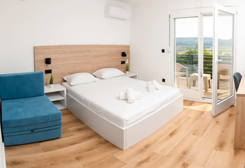 Ensuite apartment II — bedroom with balcony and mountain view
