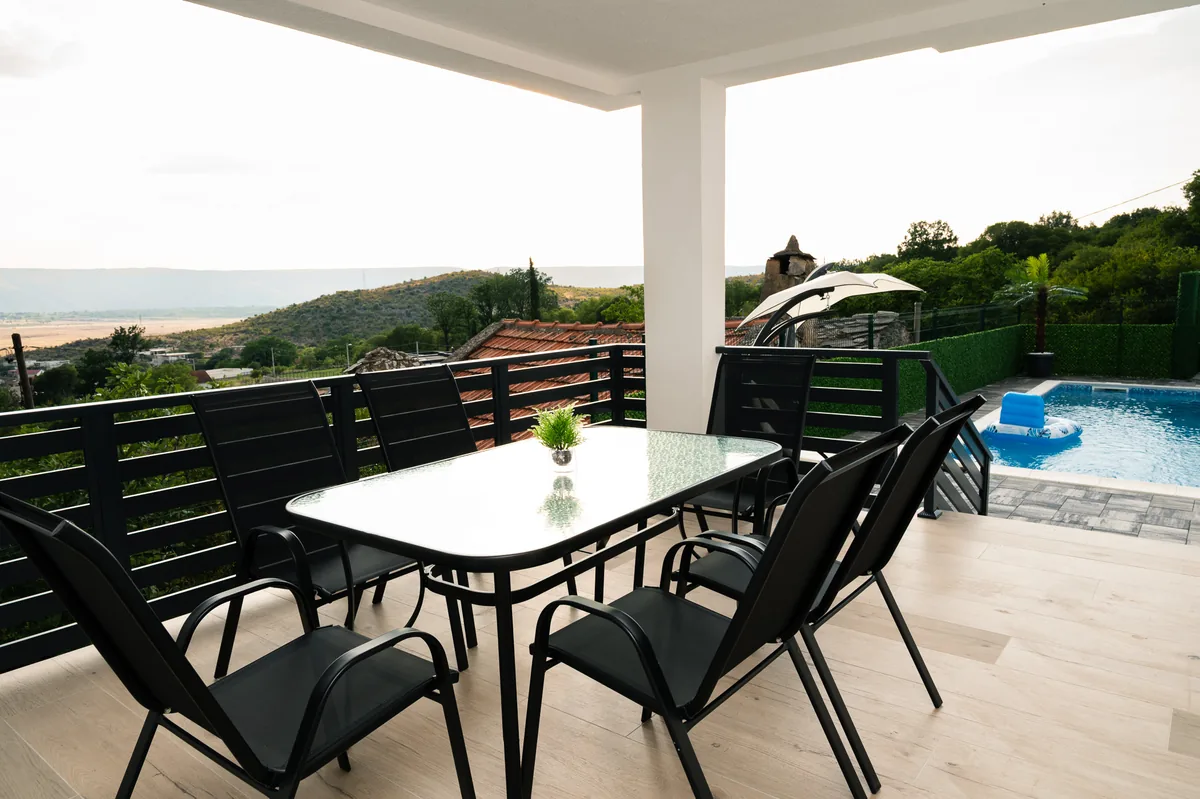 Covered terrace overlooking the pool with mountain view